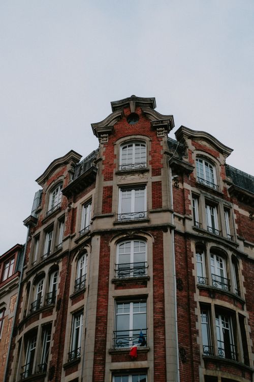 Free Low angle view of classic European building with red brick facade and multiple windows. Stock Photo