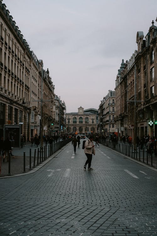 People Walking on Street Between Buildings