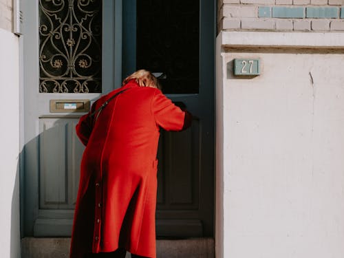 Free Backview of Person in Red Coat standing in a Doorway  Stock Photo