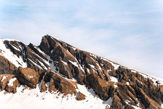 Sharp mountain peaks with snow patches against a clear blue sky, showcasing natural beauty.