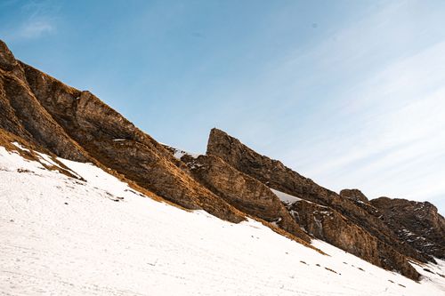 Free A stunning view of snow-capped rocky mountain peaks under a clear blue sky, capturing the essence of winter. Stock Photo