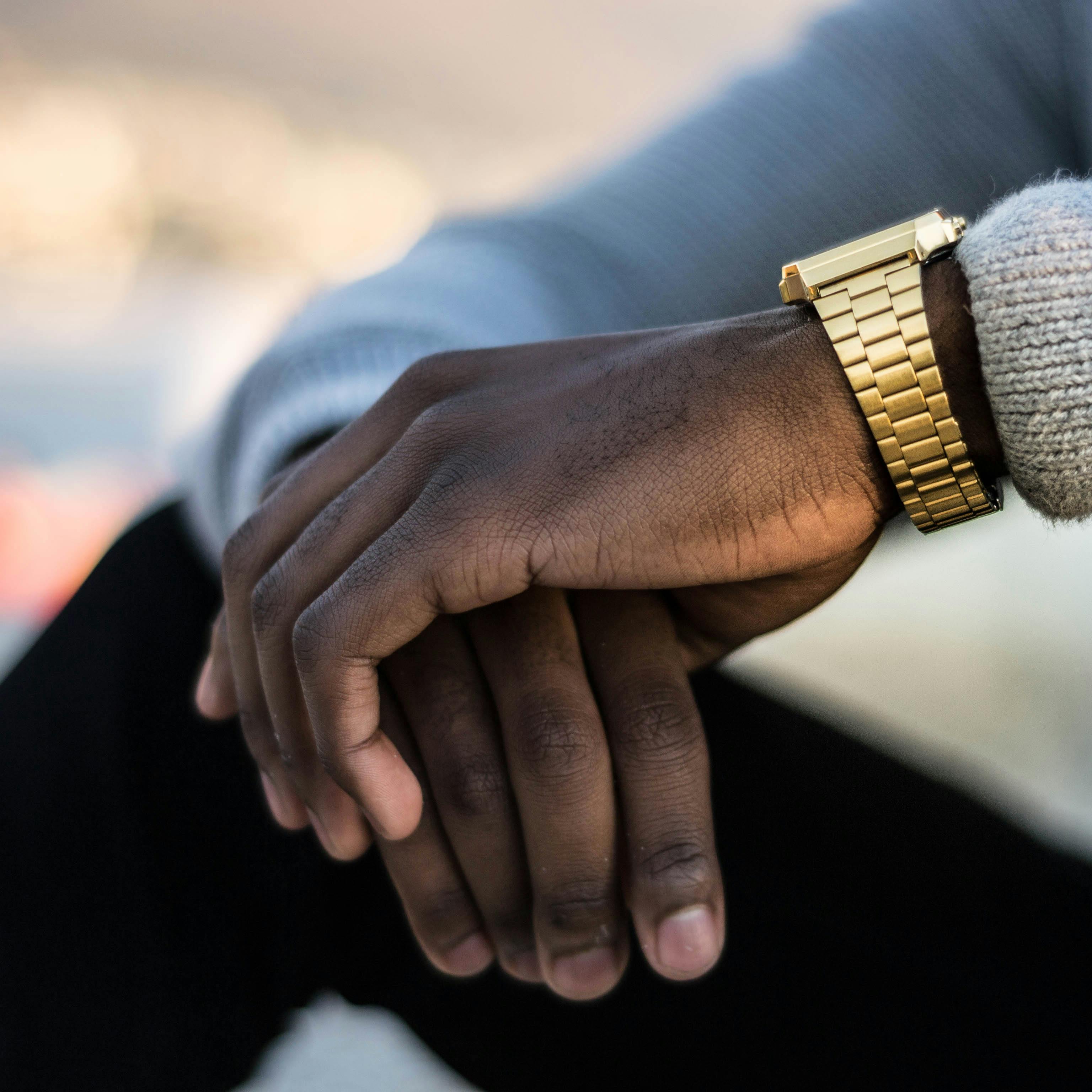 man wearing gold colored wristwatch