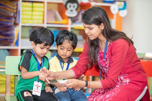Woman in Salwar Kameez Teaching Pre Schooler Kids Sitting Inside a Classroom 