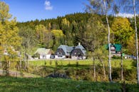 White and Gray House Surrounded by Green Trees Under Blue Sky