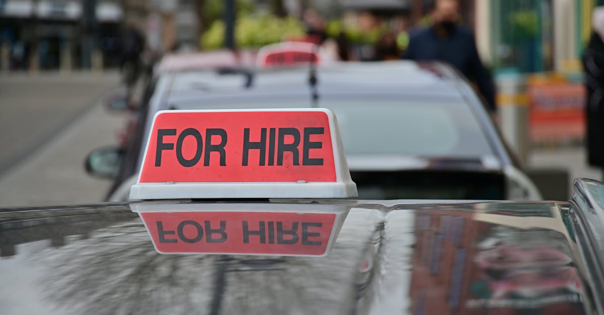 A person sitting at a desk with a headset on, looking at a computer screen with a video call in progress. A notebook and pen are next to the laptop.