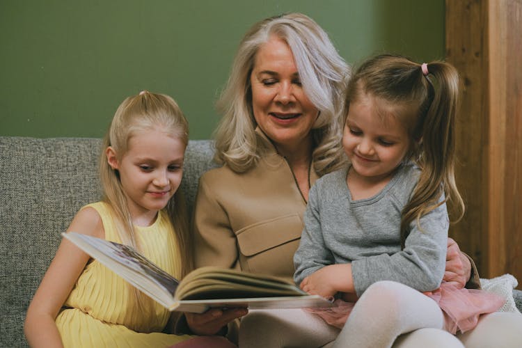 Woman Reading Book With Girls