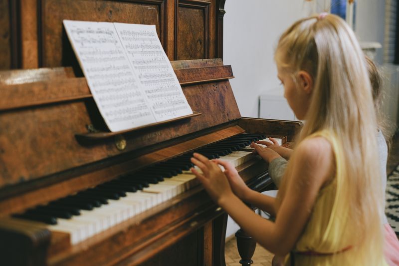 Young students sharing music at a piano