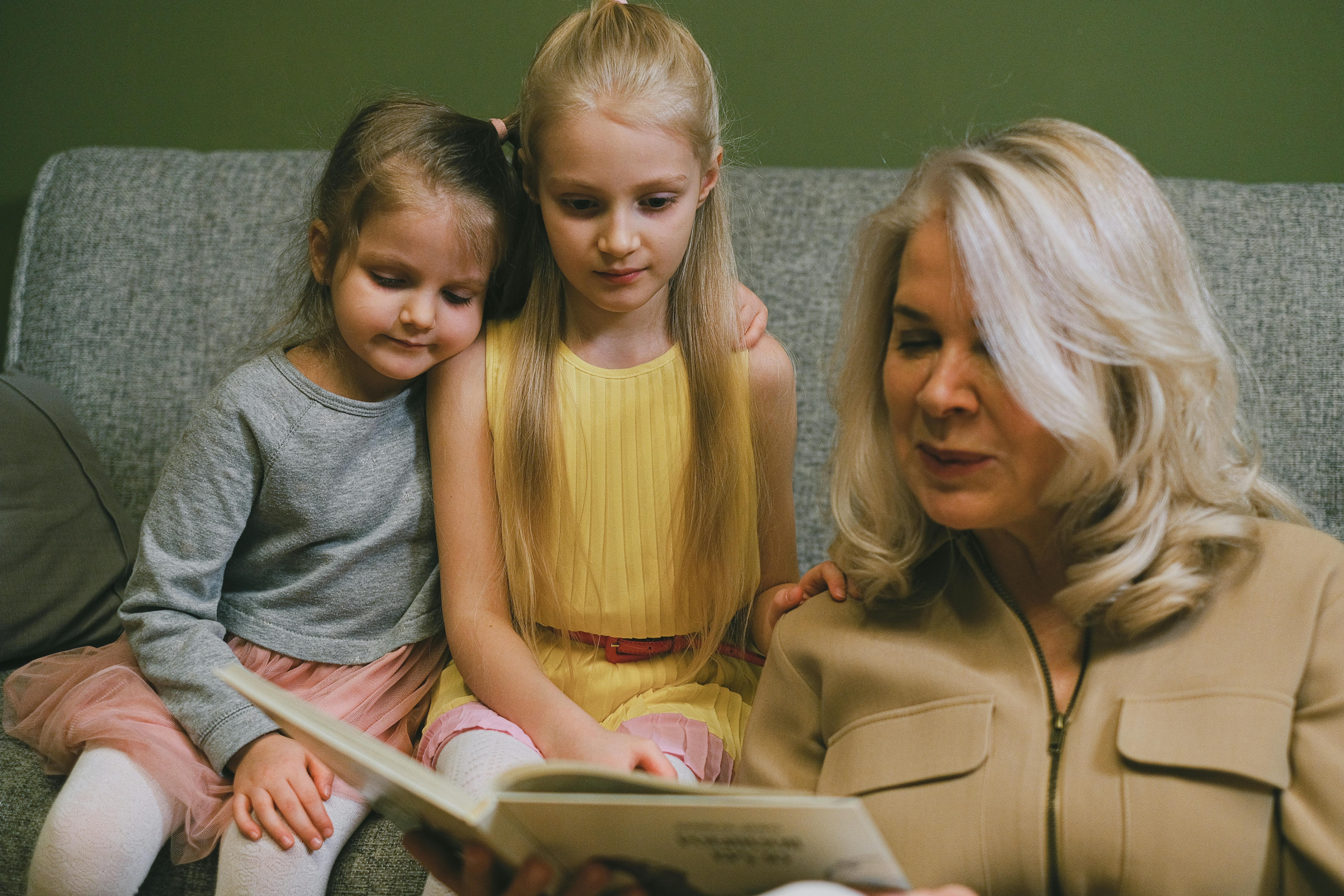 woman reading book two girls