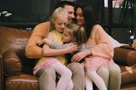 Woman in Pink Sweater Sitting Beside Girl in Pink Shirt