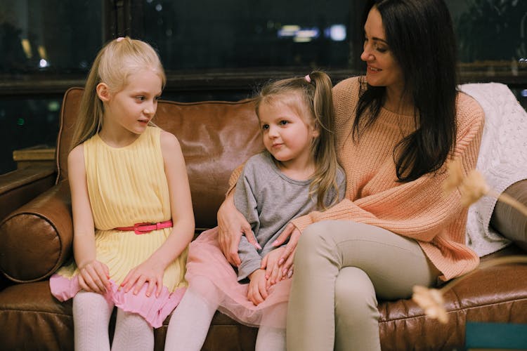 Woman Sitting On Sofa With Girls