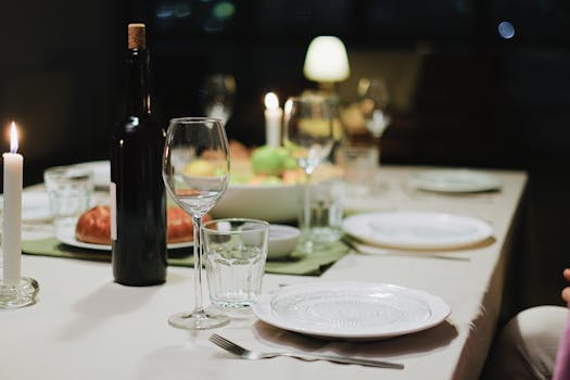 A cozy dinner setting featuring wine, candles, and a beautifully arranged table for an intimate gathering.