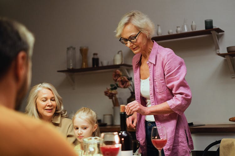 Woman In Pink Top Standing Beside A Table