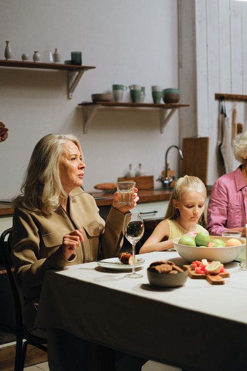 Free A family enjoying a dinner together indoors as they engage in conversation. Stock Photo