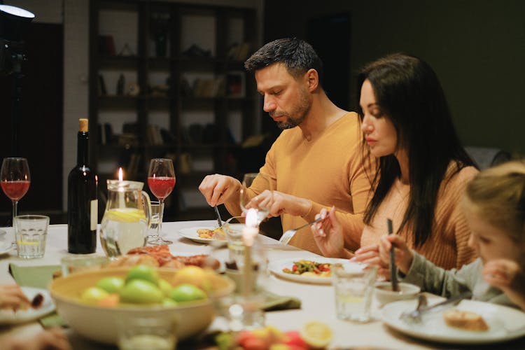 A Family Having Dinner At A Table