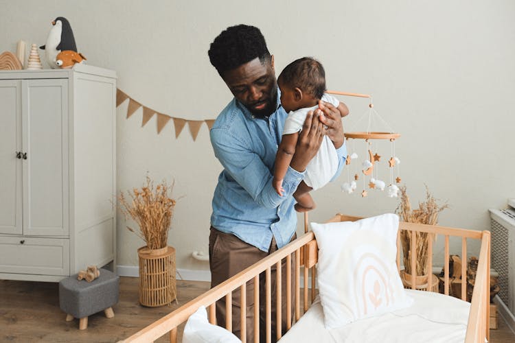 Father Putting Son On A Crib