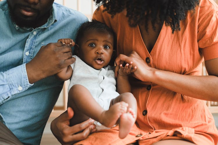 A Couple Sitting Together With Their Baby