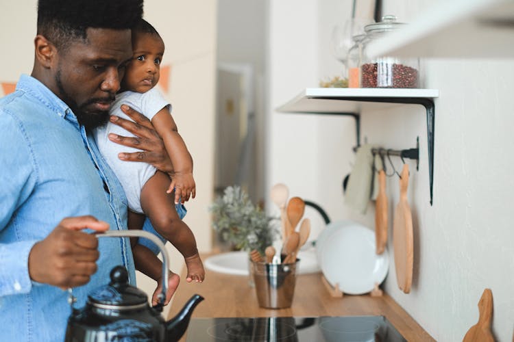 Father Holding His Son While In The Kitchen