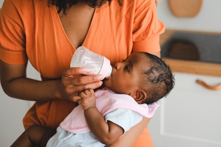 Close Up Photo Of Woman Feeding A Baby