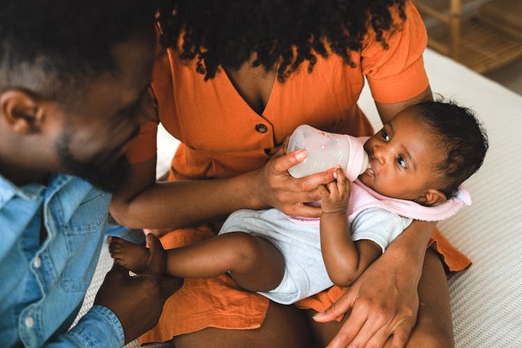 Close Up Photo Of Woman Feeding A Baby