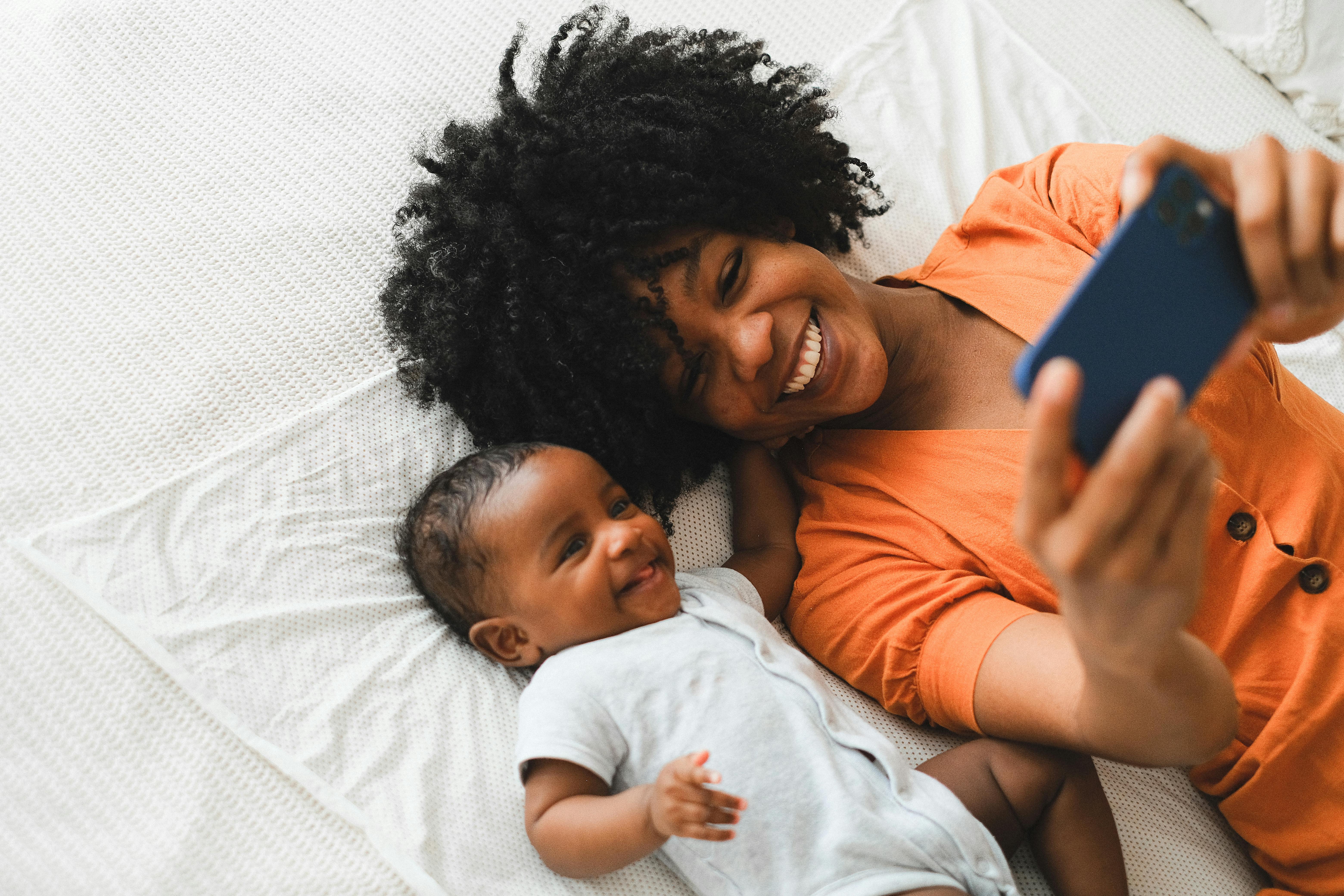 smiling woman taking selfie with a baby