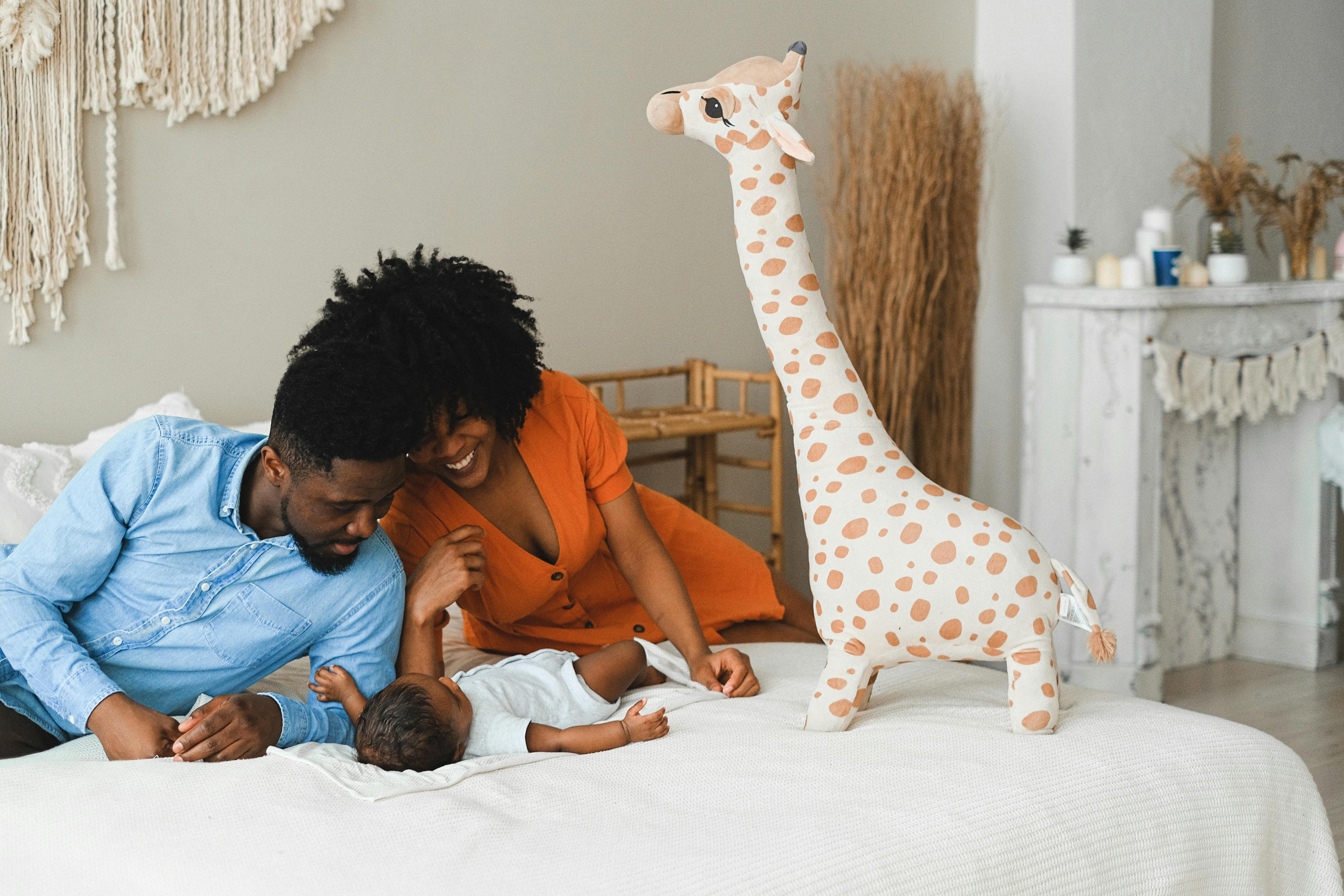 man and woman reclining on bed with a baby