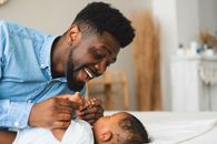 Man in Blue Dress Shirt Carrying Baby