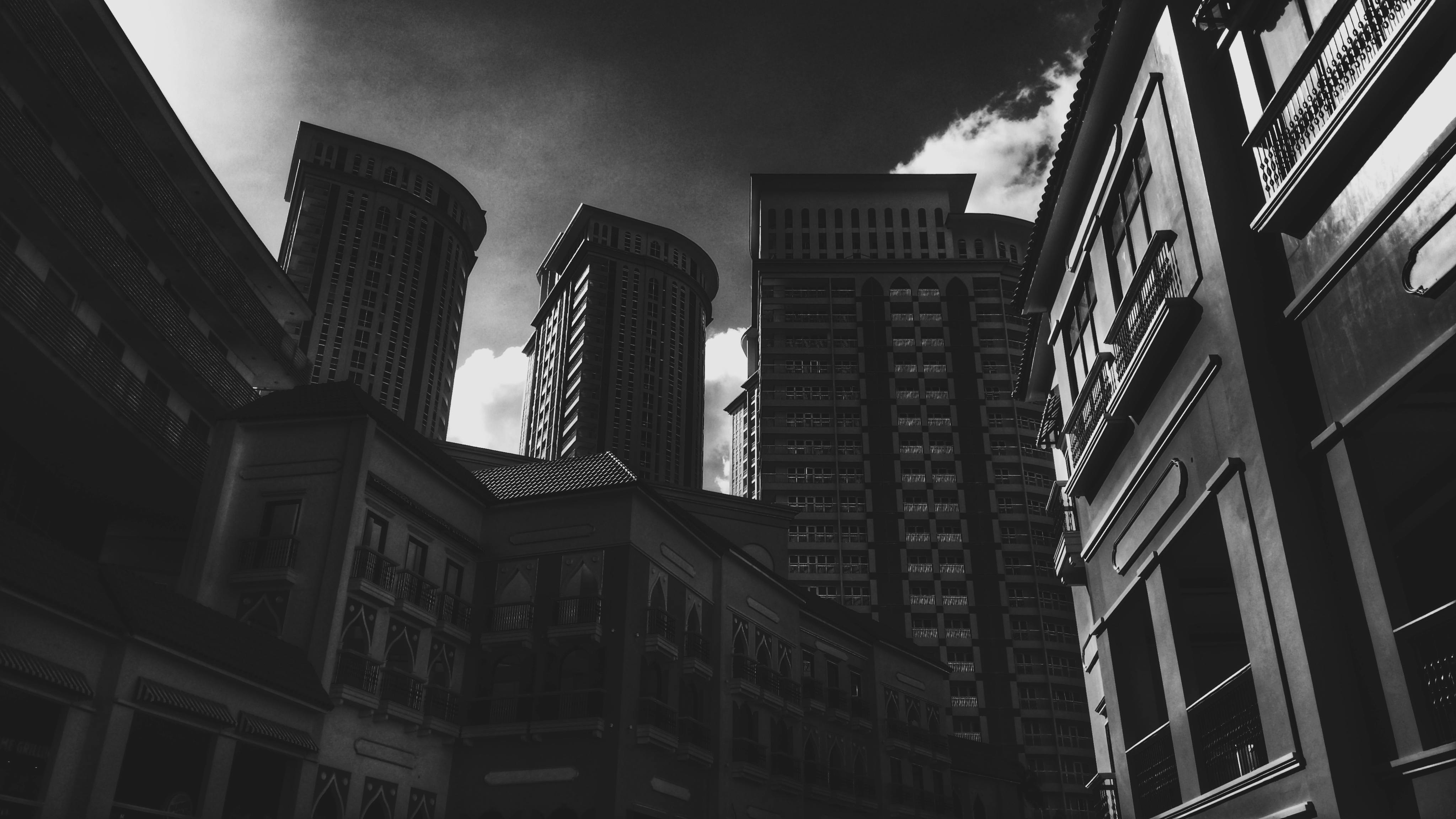 一张多云天空下城市摩天大楼的黑白照片，十分醒目