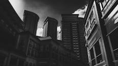 一张多云天空下城市摩天大楼的黑白照片，十分醒目