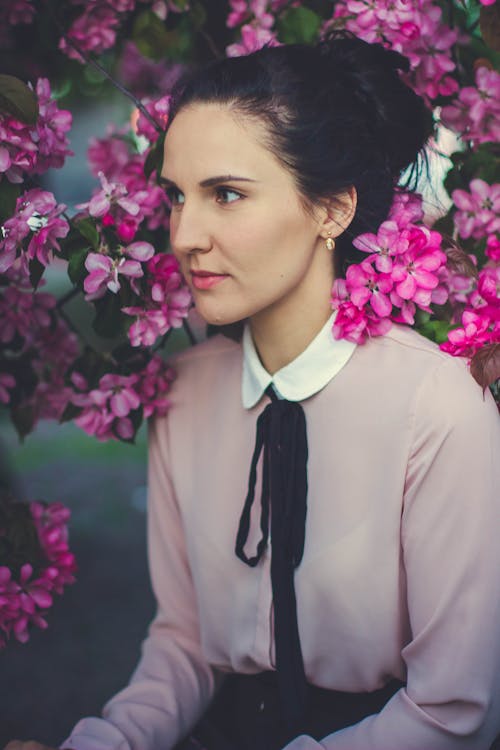 무료 분홍색 꽃잎 꽃 근처에 앉아 여자 스톡 사진