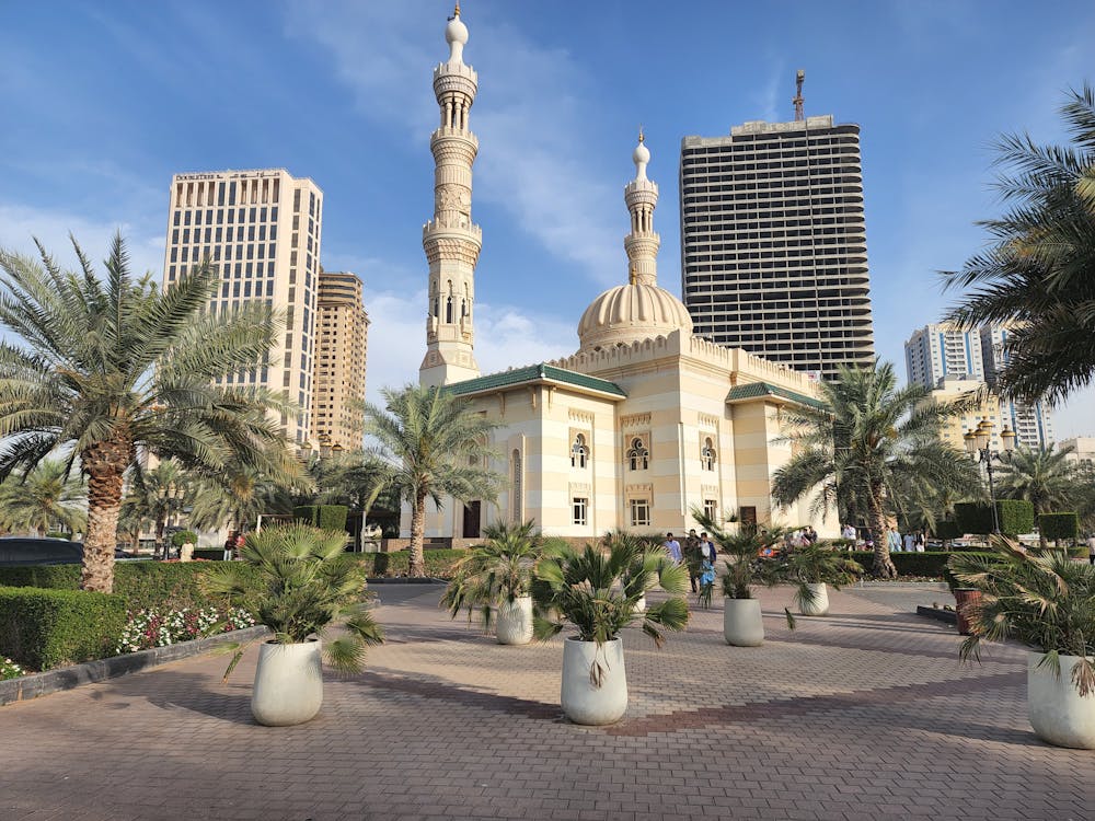 Free A stunning mosque amidst the modern skyline of Dubai, UAE, under clear blue skies.