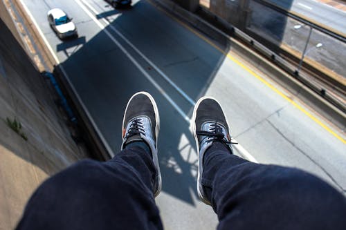 Man in Blue Pants Wearing Black and White Lace Up Low Top Sneakers