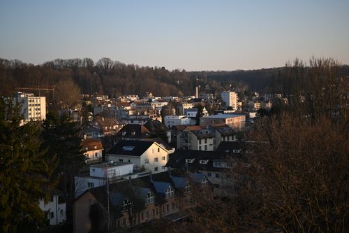 Free Aerial view of Binningen, Switzerland in winter with urban and natural elements at sunset. Stock Photo