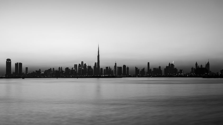 Al Ain City - City bridge crossing a calm river at dusk