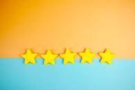 Bright yellow stars arranged on a vivid orange and blue background with copy space.