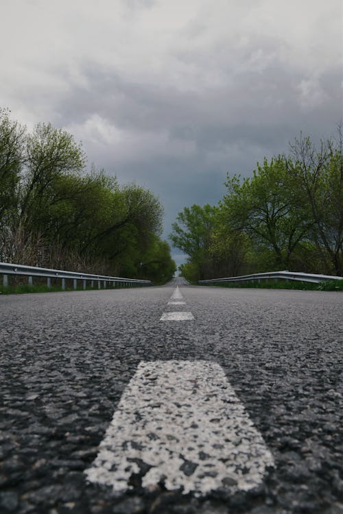 Empty Asphalt Road Under Cloudy Sky