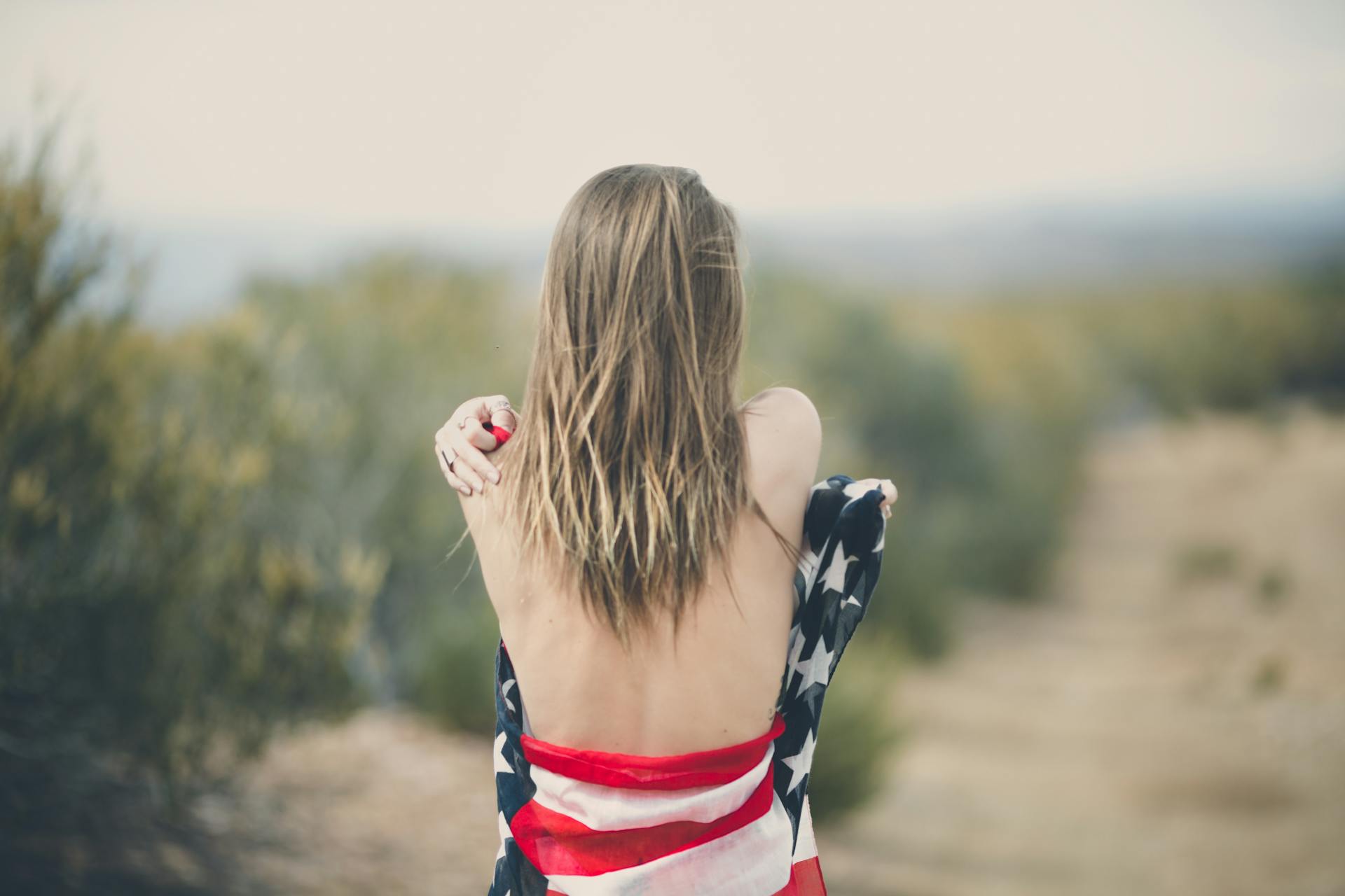 Vrouw met een Amerikaanse vlag om haar lichaam