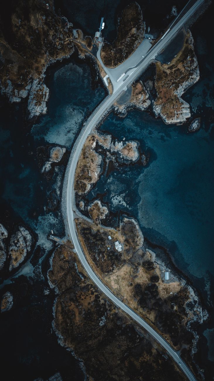 Drone shot capturing a stunning aerial view of a winding coastal road in Møre og Romsdal, Norway.