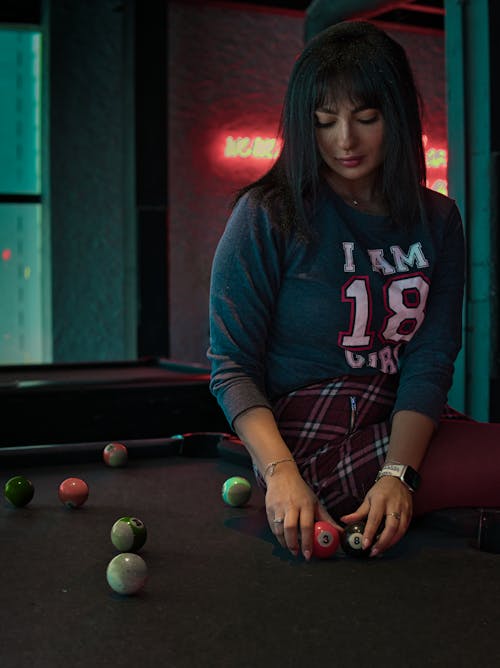 Close-Up Shot of a Woman Holding Billiard Balls