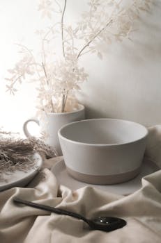 An elegant arrangement of ceramic tableware with delicate floral accents in soft, neutral tones.