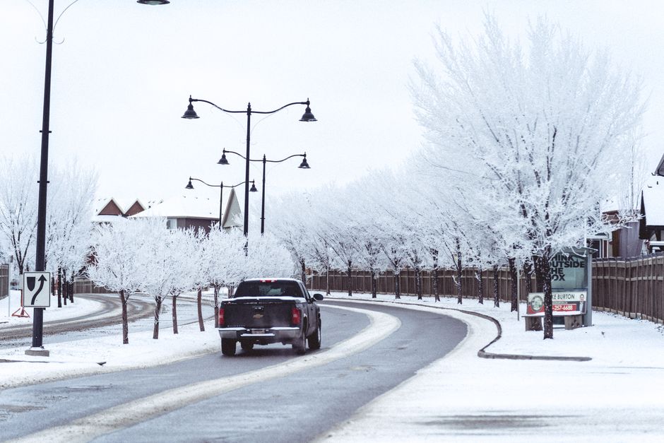 suburban neighborhood street with tow truck driving away