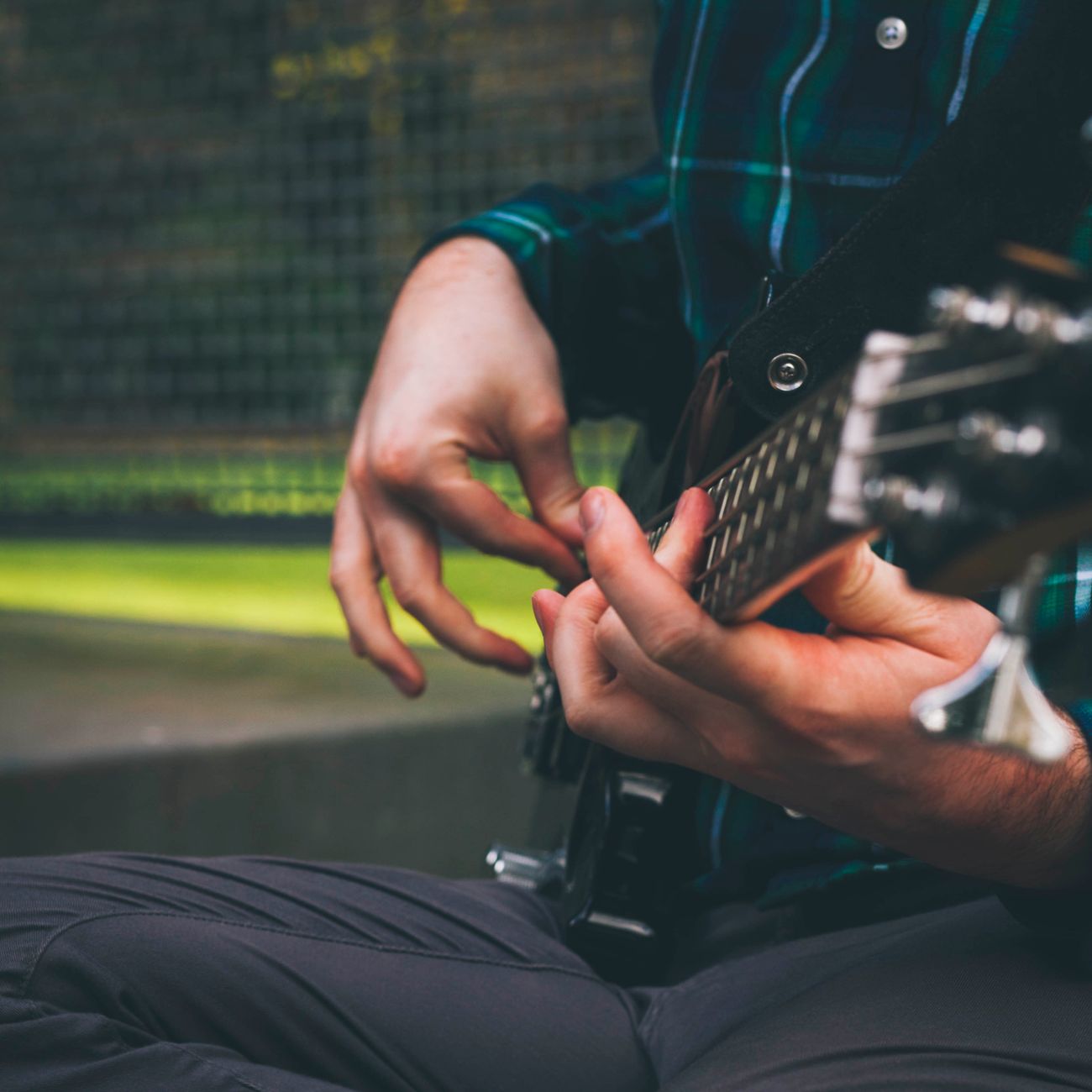 Musician strumming a bass guitar in an outdoor setting, capturing the essence of music.. musician, strumming, bass