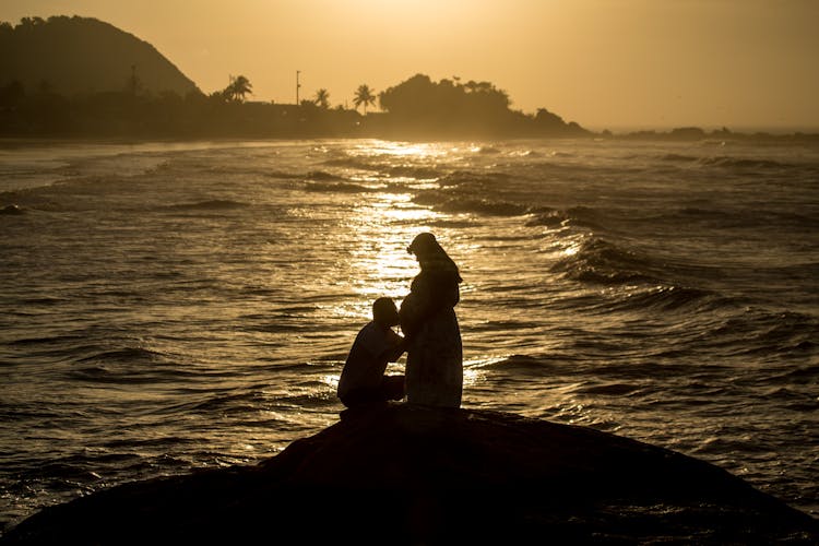 Silhouette Of A Man Kissing Belly Of A 
 Pregnant Woman 