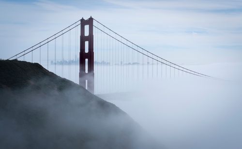 Free A stunning aerial view of the Golden Gate Bridge partially obscured by fog. Stock Photo