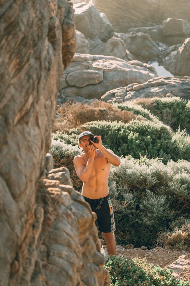 Shirtless Man Taking Photo In Mountains 