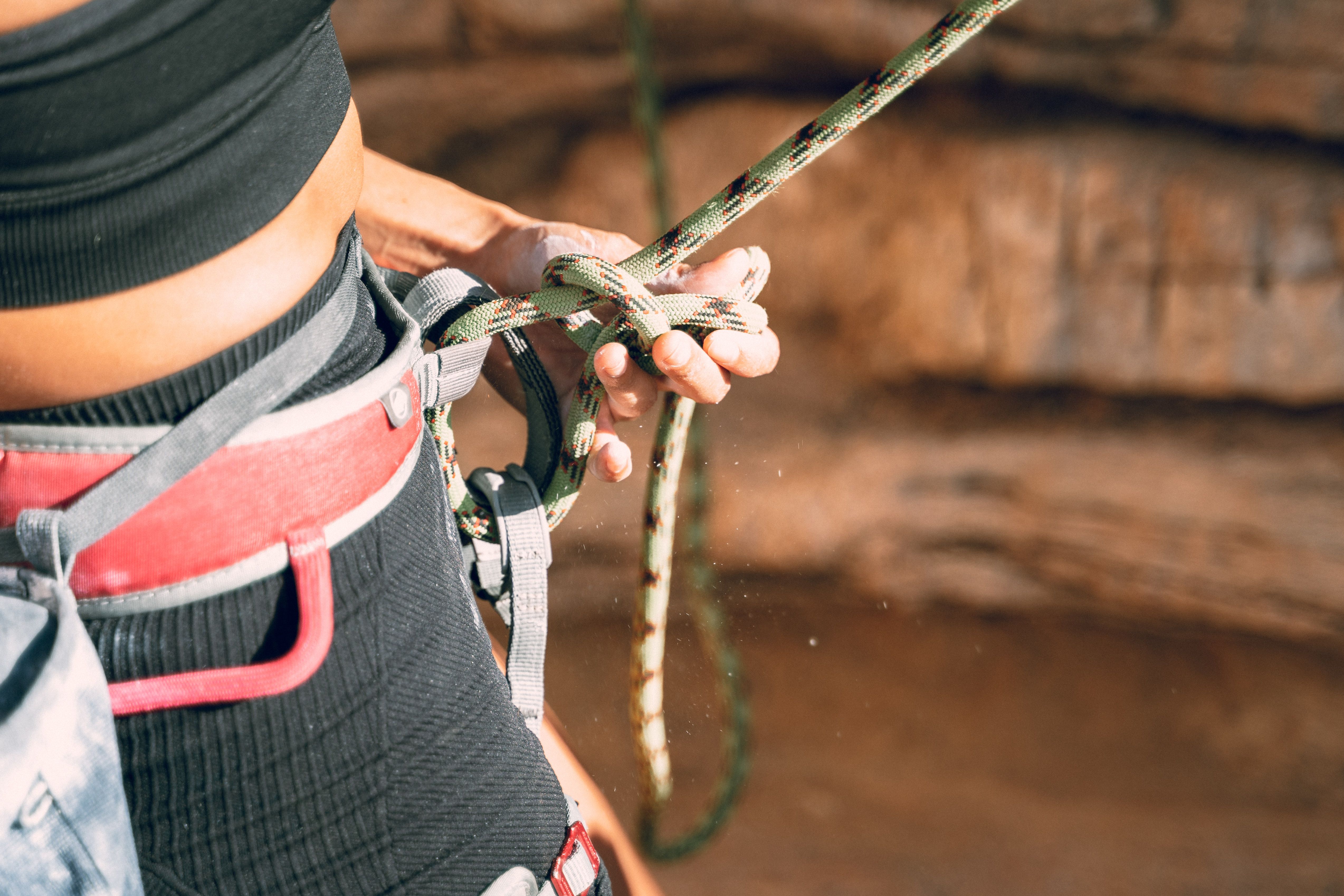 Focused image of a woman tying climbing rope, showcasing adventure and strength.