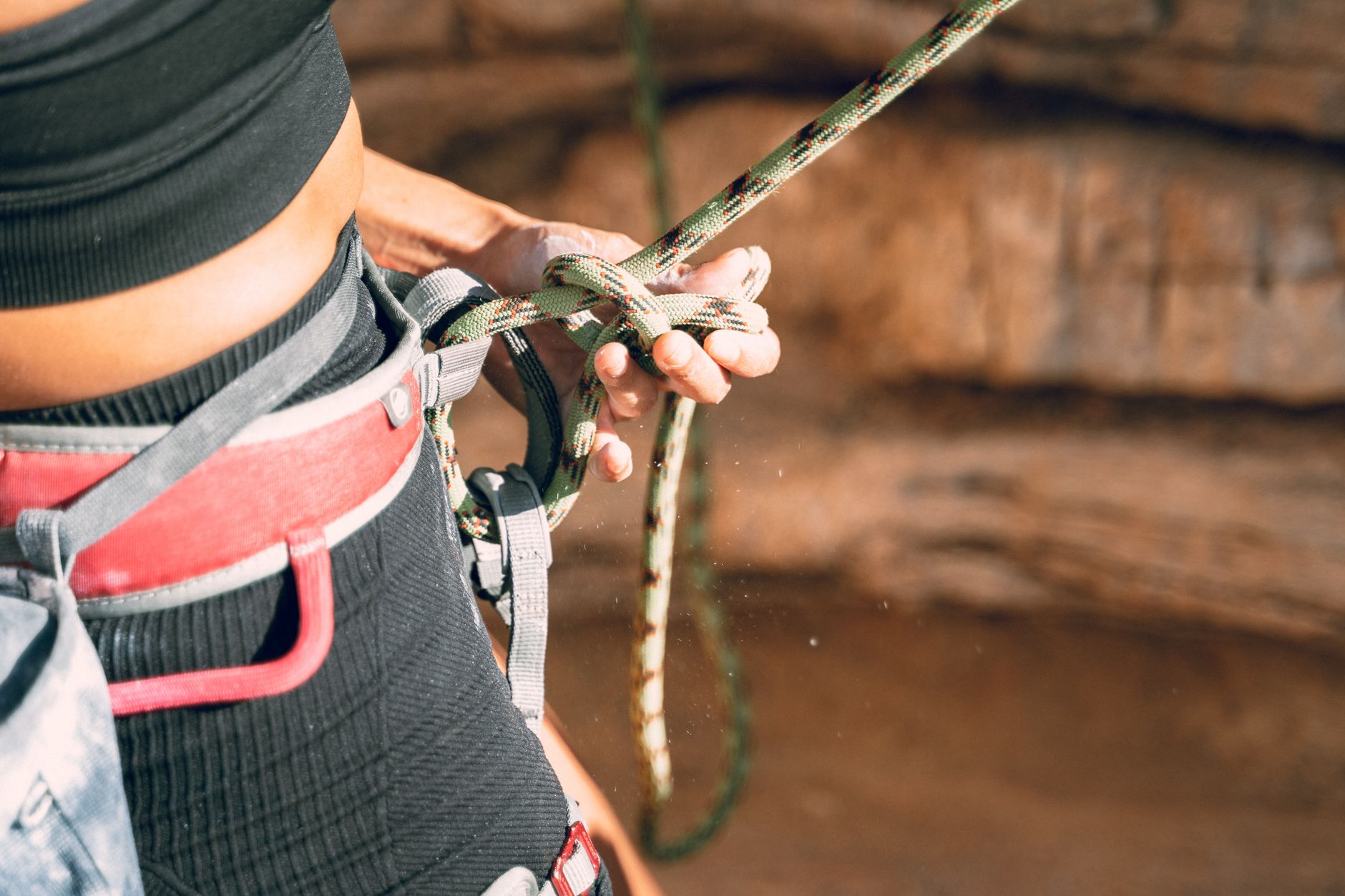 Focused image of a woman tying climbing rope, showcasing adventure and strength.