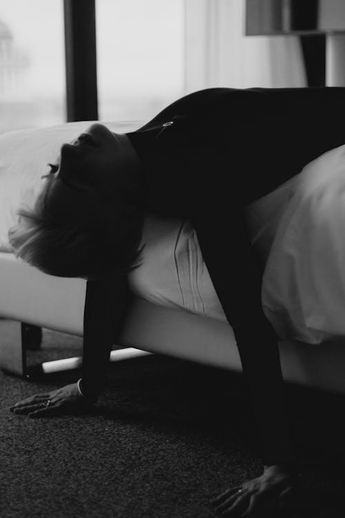 Woman in Black Long Sleeve Shirt Lying Down on Bed