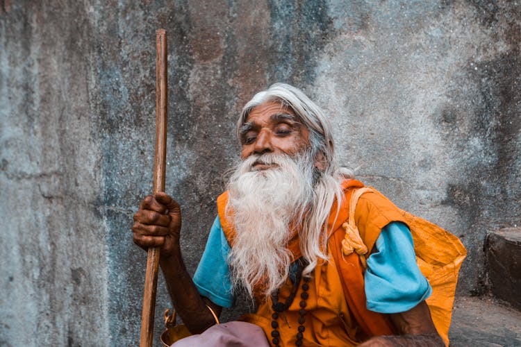 Elderly Man With A Long Gray Beard And A Stick 