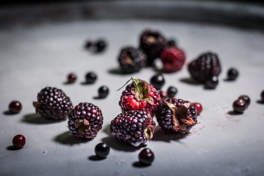 Artistic close-up of ripe blackberries and scattered berries, highlighting their juiciness.