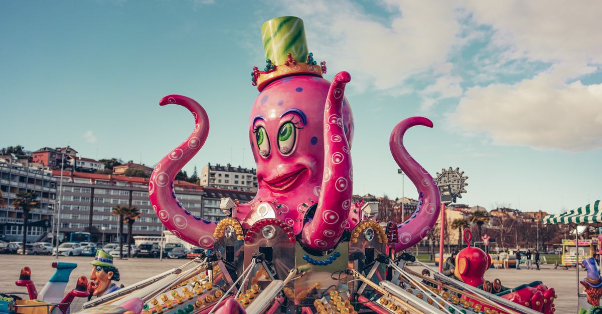 A colorful octopus-themed ride in a vibrant amusement park with blue skies in Sada, Spain.
